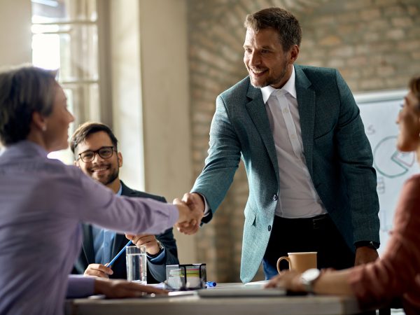 business coworkers shaking hands meeting office focus is businessman