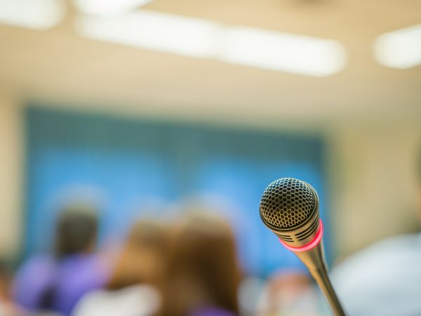 microphone with unfocused background audience